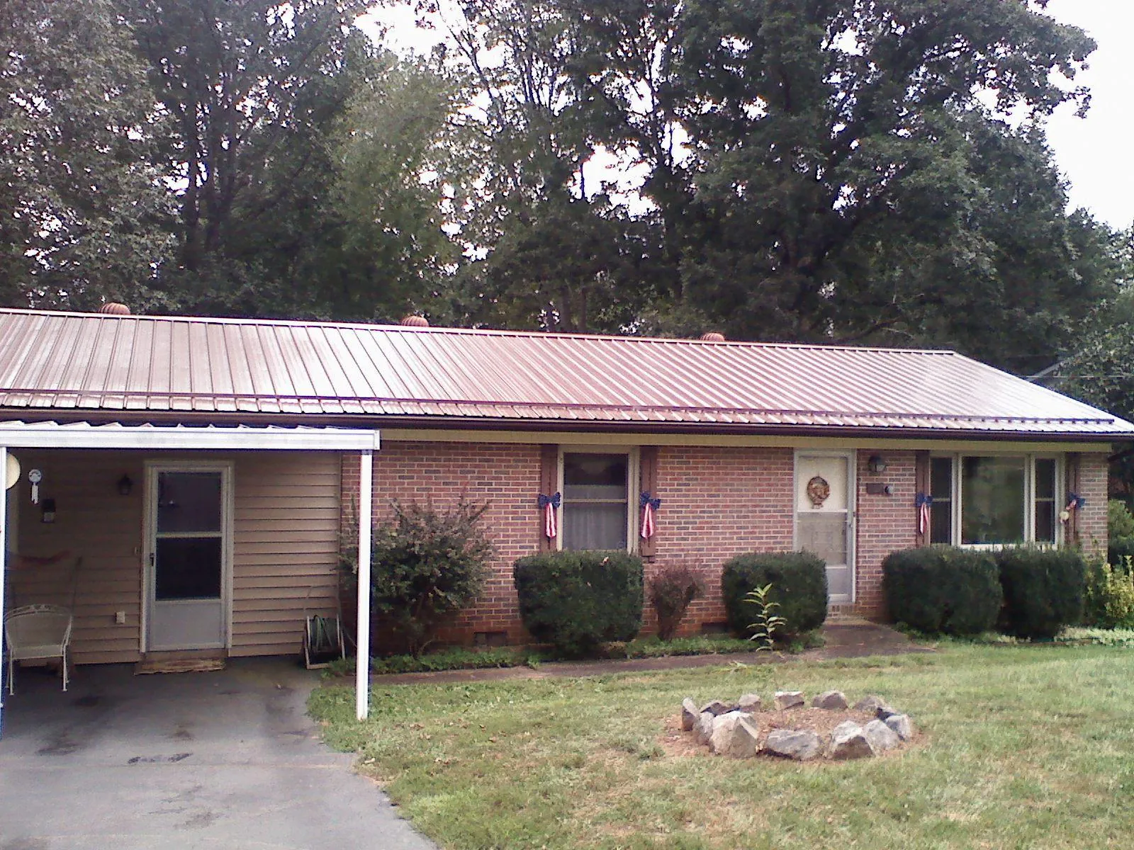 Bronze metal roof and carport on a brick ranch home — Roof Repair work by our crew in Bath